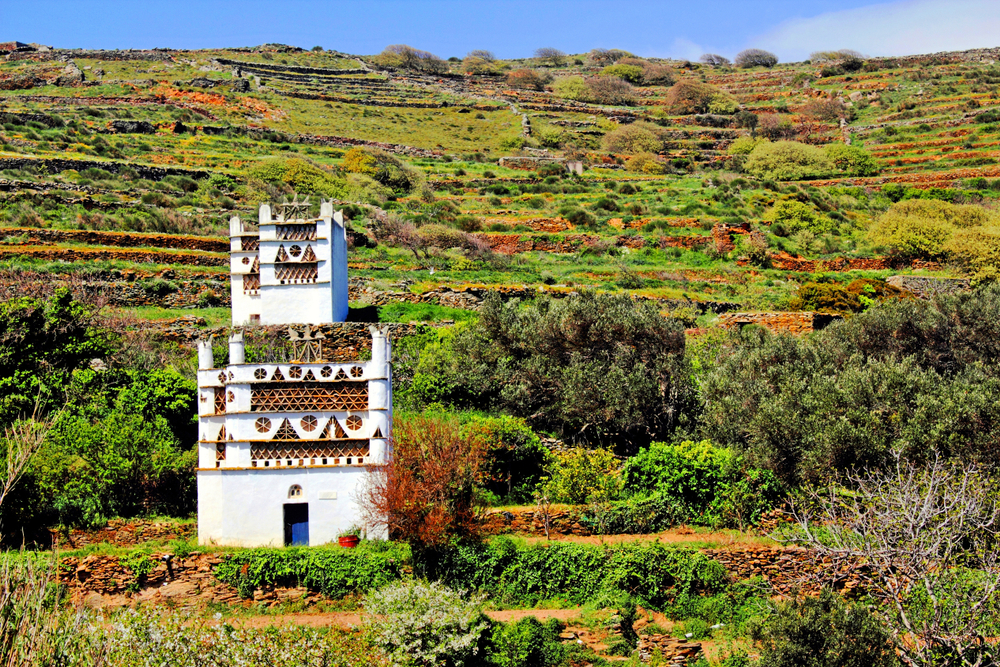 Landscape of Tarambados village with traditional dovecotes in the background. Tinos island, Cyclades islands, Greece.