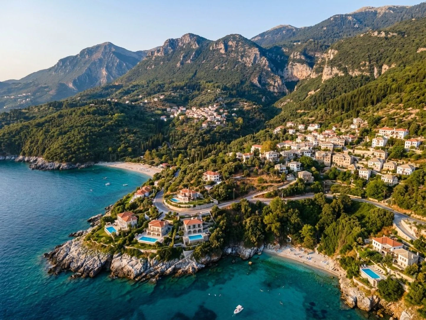 Aerial view of Pelion's mountainous coastline with traditional stone villages, lush forests, and luxury villas near turquoise beaches